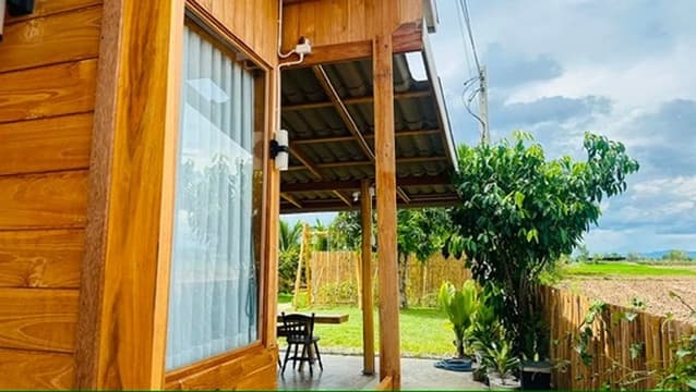 A teak porch opening onto the field.
